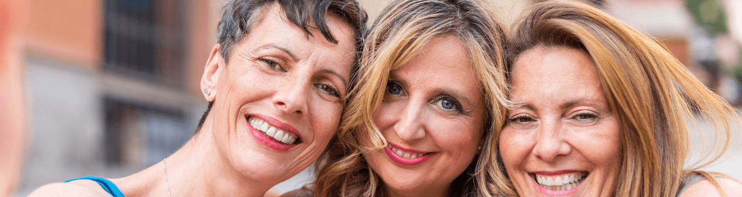 Three middle aged women smiling together